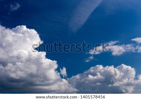 Regular spring clouds on blue sky at daylight in continental europe. Close shot wit telephoto lens and polarizing filter.