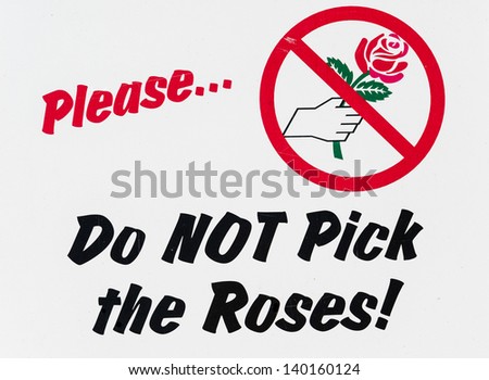 Colorful "Do not pick the roses!" sign in park