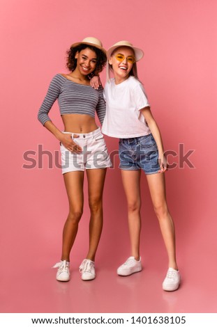Full-length photo of happy diverse millennial girls in stylish summer wear, pink background