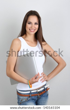 Beautiful young woman with laptop in room