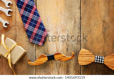Father's day concept. gift box, tie and funny moustache over wooden background. top view, flat lay