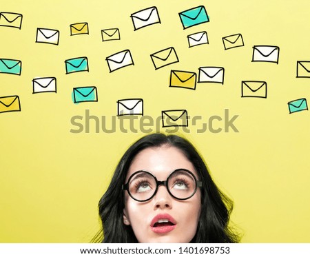Many emails with young woman wearing eye glasses