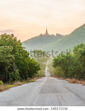 Rural road to Ancient Thai temple ,Wat Phra Phutthabat Tak Pha , Lamphun  province in northern of Thailand, sunlight as  background