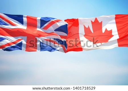 British and Canadian flags against the background of the blue sky
