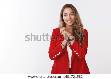 Thankful pleased young gorgeous european curly-haired woman, wearing red jacket pressing palms together grateful, appreciating cute romantic gesture, smiling receiving bday congratulations