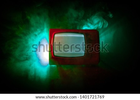 Old vintage red TV with white noise on dark toned foggy background. Retro old Television reciever no signal. Selective focus