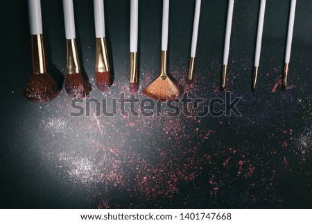 Set of professional makeup brushes on black background
