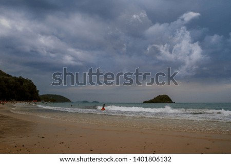 Many people relaxing on the beach with dark cloudy from the thunder storm before hard raining. Background for meteorology or environmental or natural disaster concept. 