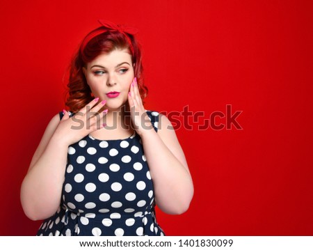Closeup of pretty fat redhead woman surprise holds cheeks by hand. pinup girl isolated on retro vintage 50s style. Human emotions body language positive face