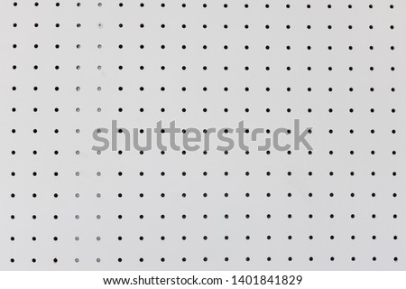 orderly holes or dot rows and columns on white pegboard wall. Royalty-Free Stock Photo #1401841829