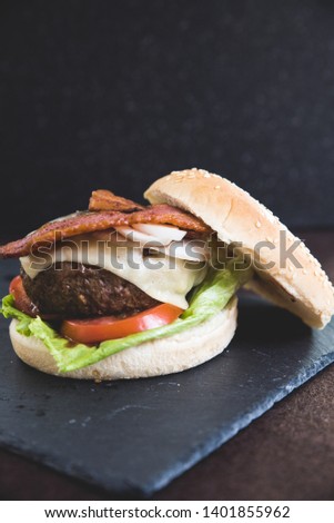 Delicious burgers with beef patty, bacon, cheese and cabbage 