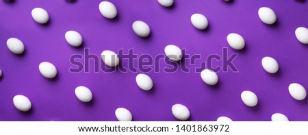 Food concept with white chicken eggs on violet background. Top view. Creative pattern in minimal style. Flat lay. Colorful banner.