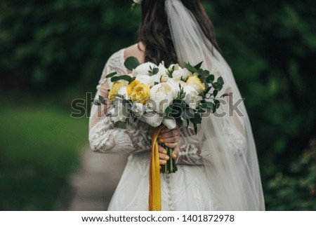 Wedding bouquet in bride's hands.  Young bride in wedding dress holding bouquet.