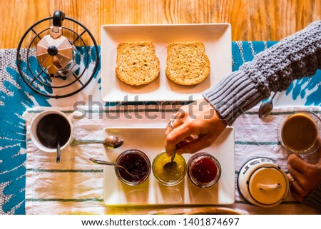 Top view of table full of food and beverage for breakfast morning time activit - fruit and coffee for healthy natural lifestyle people - woman eating bread with marmalade and drink cappuccino