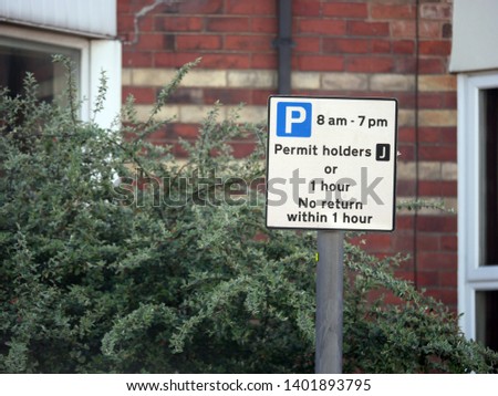 Concept of parking restrictions in urban residential area shown by sign with access for permit holders or half an hour for others with no return within 1 hour