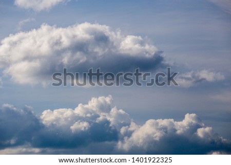 Regular spring clouds on blue sky at daylight in continental europe. Shot wit telephoto lens and polarizing filter.