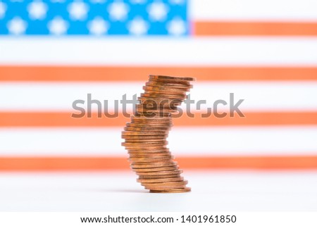 Coins stacked on each other in different positions on red and white background. US economy.
