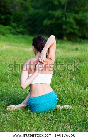 A young woman practices yoga in the park 
