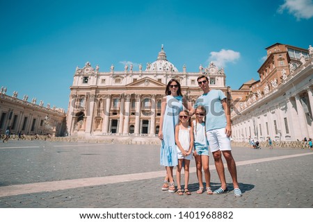 Portrait of happy young family at St. Peter's Basilica church in Vatican city, Rome. Travel parents and kids on european vacation in Italy.