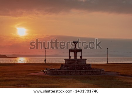 Sunset falling on a statue on the beach front at Largs. Spring/Summer 2019