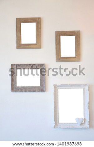 Various collection of photo frames on a white wall.