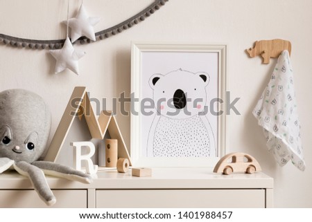 Stylish scandinavian newborn baby shelf with mock up photo frame, mountain box, plush octopus, wooden toys. Gray garland and white stars. Modern interior with white walls and wooden accessories.