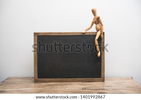 vintage blackboard with wooden frame with wooden doll