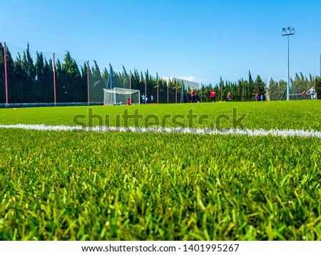 Image of artificial grass in the foreground and background of children playing soccer Royalty-Free Stock Photo #1401995267