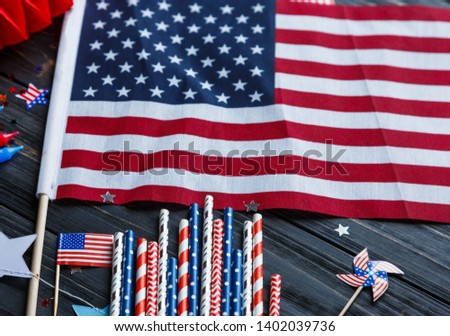 Decorations for 4th of July day of American independence, flag, straws. USA holiday decorations on a wooden background, top view, flat lay