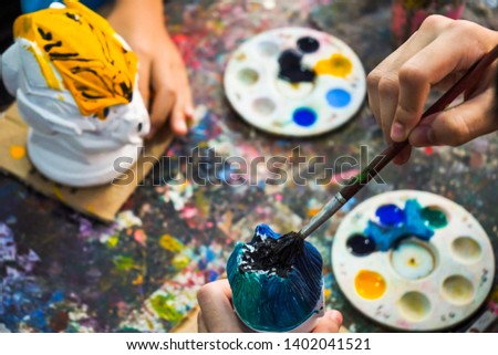 Children painting watercolor on stucco dolls in relax time.