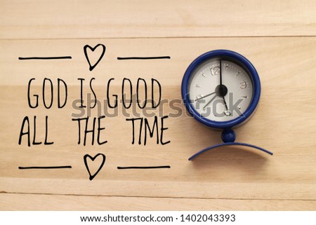 Motivational or religious quote - God is good all the time with background of wood and blue small clock
