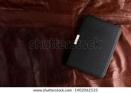 Electronic book in the case on leather background