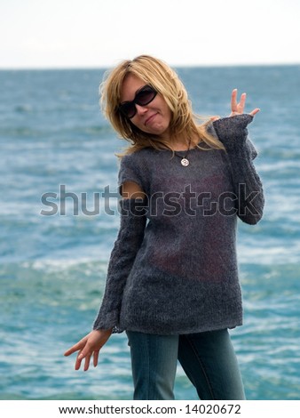 Young blond model posing beach in sunglasses