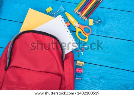Top view Red bag backpack for education children on blue wooden  background back to school concept