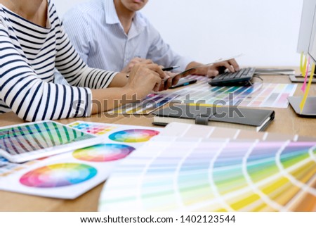 group of young worker for graphic design working on wood table with computer tablet electronic pen and color chart, graphic art concept