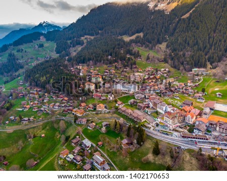 Aerial shot of Wengen town in Switzerland, with the Swiss Alps of Jungfrau region in the background.