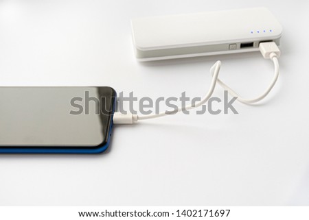 Smartphone connect to power bank. Portable charger on a white background. Charging your phone