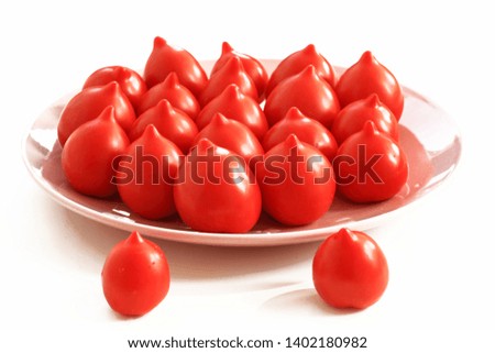 Red ripe long-nosed tomatoes on a pink porcelain dish