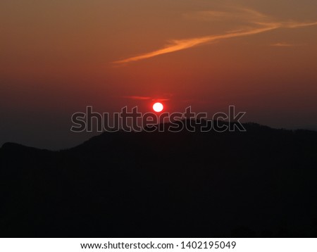 the picture of the sun rises on the mountain in orange