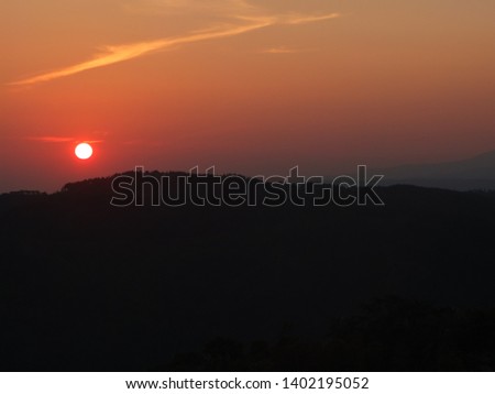 the picture of the sun rises on the mountain in orange