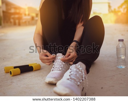 young women is tying sport shoes