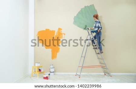 Woman painting wall indoors, space for text. Home repair
