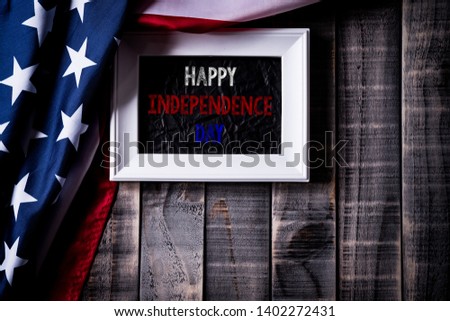 Top view of white picture frame with Flag of the United States of America on wooden background.  Independence Day USA, Memorial.
