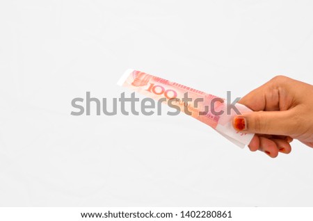 Hand hold cash of China money RMB100 on white background. Selective focus.