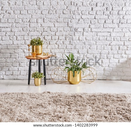 White brick wall, gold vase of flower and coffee table style, carpet detail decor.