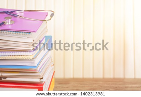Stethoscope with a stack of reference books isolated
