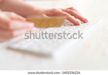 Hands holding plastic credit card and using keyboard. Online shopping concept.