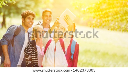 Group taking salfie for social media in the park in summer