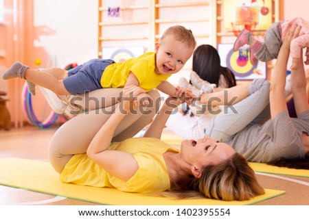 Yoga for babies. Child-friendly fitness for women with kids toddlers. Lifestyle concept of parent activity with children.
