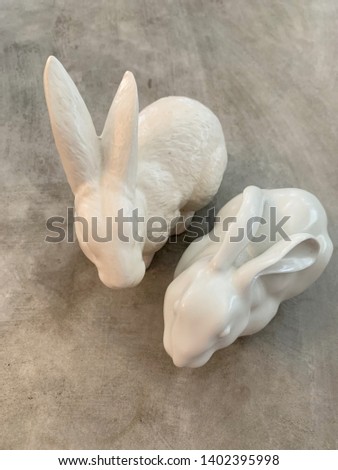 couple white rabbit ceramic on cement table Royalty-Free Stock Photo #1402395998